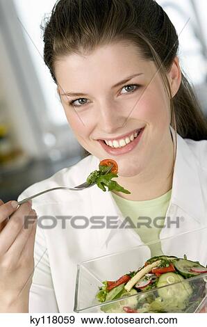 Portrait of a young smiling woman eating mixed salad View Large Photo Image Stock Photo - Portrait of a young smiling woman eating mixed salad. Fotosearch