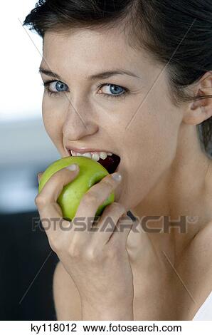 Portrait of a young woman eating an apple View Large Photo Image Stock Image - Portrait of a young woman eating an apple. Fotosearch