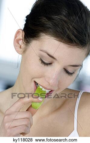 Portrait of a young woman eating apple slice View Large Photo Image Stock Photo - Portrait of a young woman eating apple slice. Fotosearch