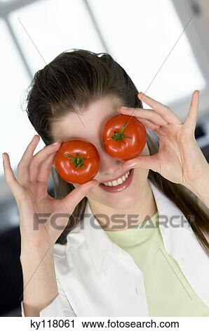 Portrait of a young woman hiding her eyes with 2 tomatoes View Large Photo Image Stock Image - Portrait of a young woman hiding her eyes with 2 tomatoes. Fotosearch