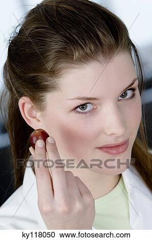 Portrait of a young woman holding a red grape View Large Photo Image Stock Image - Portrait of a young woman holding a red grape. Fotosearch