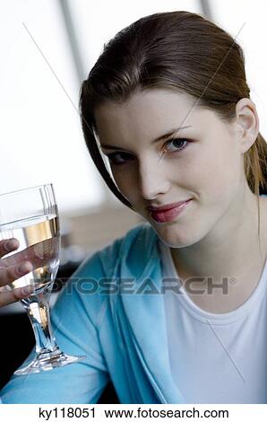 Portrait of a young woman holding a glass of water View Large Photo Image Stock Image - Portrait of a young woman holding a glass of water. Fotosearch