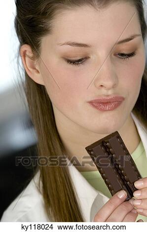 Portrait of a young woman holding chocolate bar View Large Photo Image Picture - Portrait of a young woman holding chocolate bar. Fotosearch
