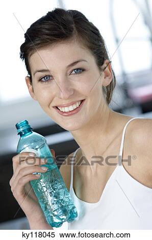 Portrait of a young woman holding mineral water bottle View Large Photo Image Stock Photography - Portrait of a young woman holding mineral water bottle. Fotosearch