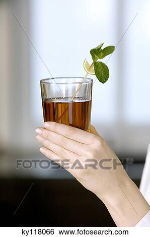Woman holding a glass of tea, close-up View Large Photo Image Stock Photograph - Woman holding a glass of tea, close-up. Fotosearch