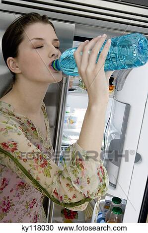 Young woman drinking water from bottle View Large Photo Image Stock Image - Young woman drinking water from bottle. Fotosearch
