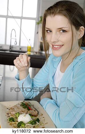 Young woman eating meat and rice View Large Photo Image Stock Image - Young woman eating meat and rice. Fotosearch