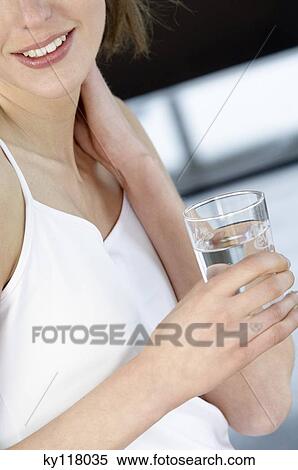 Young woman holding a glass of water View Large Photo Image Stock Photography - Young woman holding a glass of water. Fotosearch