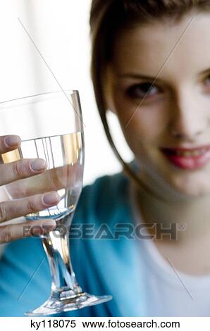 Young woman holding a glass of water, close-up View Large Photo Image Stock Photography - Young woman holding a glass of water, close-up. Fotosearch