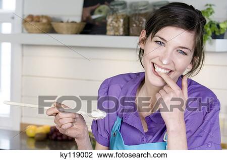 Portrait of a smiling woman tasting food View Large Photo Image Stock Image - Portrait of a smiling woman tasting food. Fotosearch