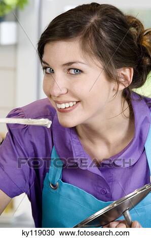 Portrait of a young smiling woman tasting food View Large Photo Image Stock Image - Portrait of a young smiling woman tasting food. Fotosearch