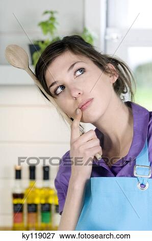 Portrait of a young thinking woman, holding a wooden spoon View Large Photo Image Stock Photo - Portrait of a young thinking woman, holding a wooden spoon. Fotosearch