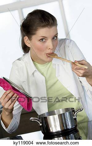 Portrait of a young woman tasting food View Large Photo Image Picture - Portrait of a young woman tasting food. Fotosearch