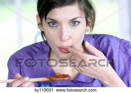 Portrait of a young woman tasting food View Large Photo Image Stock Image - Portrait of a young woman tasting food. Fotosearch