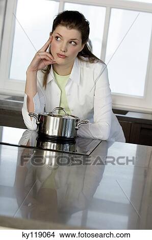 Thinking woman in front of saucepan on vitroceramic hob View Large Photo Image Picture - Thinking woman in front of saucepan on vitroceramic hob. Fotosearch