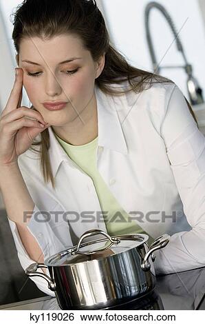 Thinking woman watching over saucepan on vitroceramic hob View Large Photo Image Stock Photograph - Thinking woman watching over saucepan on vitroceramic hob. Fotosearch
