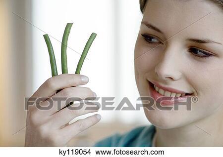 Woman holding 3 string beans, close-up View Large Photo Image Picture - Woman holding 3 string beans, close-up. Fotosearch
