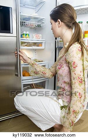 Woman looking into refrigerator View Large Photo Image Stock Image - Woman looking into refrigerator. Fotosearch