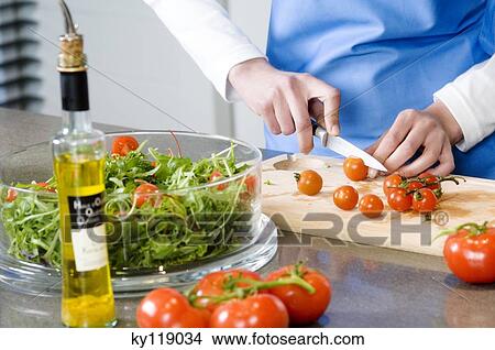 Woman making a salad, chopping tomatoes, close-up View Large Photo Image Picture - Woman making a salad, chopping tomatoes, close-up. Fotosearch