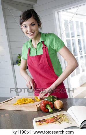 Young smiling woman chopping vegetables View Large Photo Image Stock Image - Young smiling woman chopping vegetables. Fotosearch