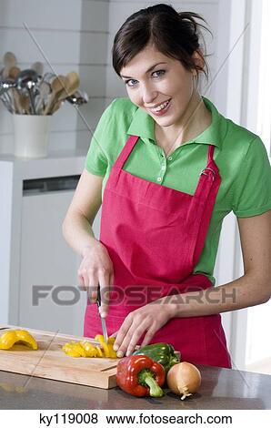 Young smiling woman chopping vegetables View Large Photo Image Stock Photo - Young smiling woman chopping vegetables. Fotosearch