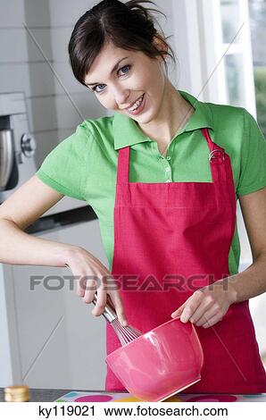 Young smiling woman mixing ingredients with whisk in a bowl View Large Photo Image Stock Image - Young smiling woman mixing ingredients with whisk in a bowl. Fotosearch