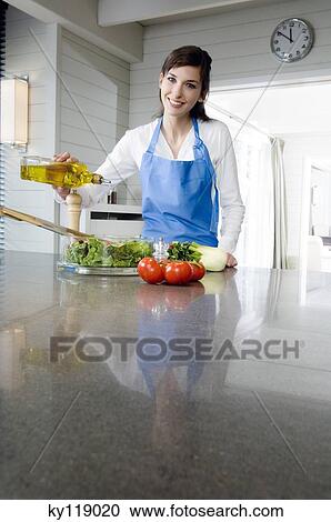Young smiling woman pouring olive oil into a salad View Large Photo Image Stock Image - Young smiling woman pouring olive oil into a salad. Fotosearch