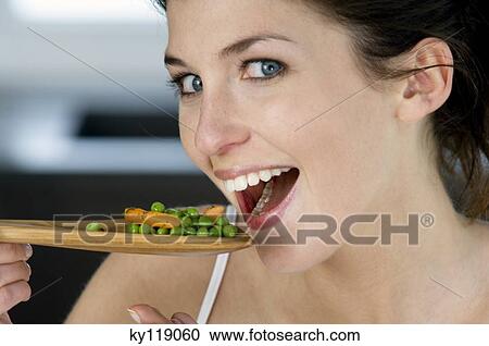 Young smiling woman tasting cooked vegetables View Large Photo Image Stock Image - Young smiling woman tasting cooked vegetables. Fotosearch