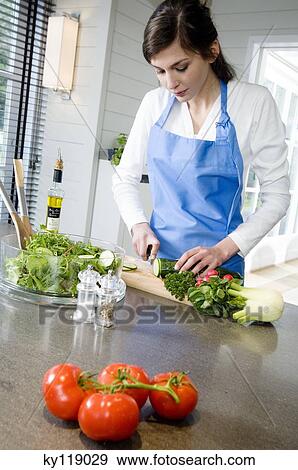 Young woman chopping vegetables View Large Photo Image Stock Photo - Young woman chopping vegetables. Fotosearch