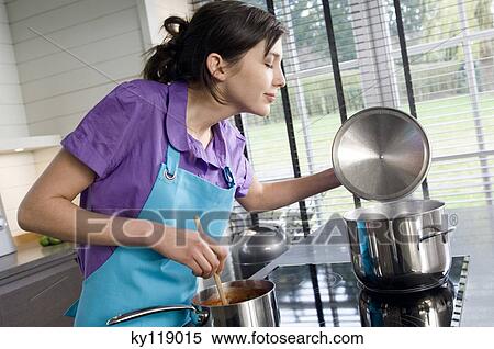 Young woman cooking View Large Photo Image Stock Photography - Young woman cooking. Fotosearch