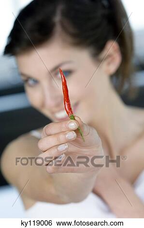 Young woman showing red pepper to the camera, close-up View Large Photo Image Stock Photograph - Young woman showing red pepper to the camera, close-up. Fotosearch