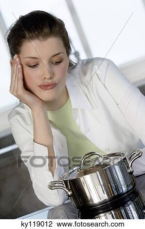 Young woman watching over saucepan on vitroceramic hob View Large Photo Image Stock Image - Young woman watching over saucepan on vitroceramic hob. Fotosearch