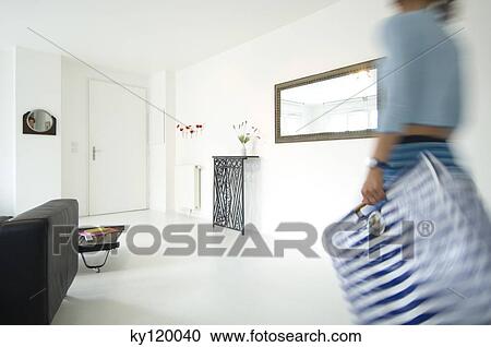 Woman carrying a bag in a living-room View Large Photo Image Stock Image - Woman carrying a bag in a living-room. Fotosearch