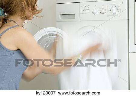 Stock Photo - Woman emptying washing machine. Fotosearch