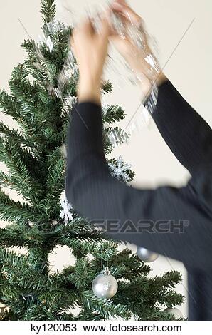Woman hanging decoration on Christmas tree, close-up View Large Photo Image Stock Image - Woman hanging decoration on Christmas tree, close-up. Fotosearch