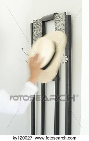 Woman hanging hat, close-up View Large Photo Image Stock Photo - Woman hanging hat, close-up. Fotosearch