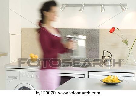 Woman in the kitchen carrying a steam cooker View Large Photo Image Stock Image - Woman in the kitchen carrying a steam cooker. Fotosearch
