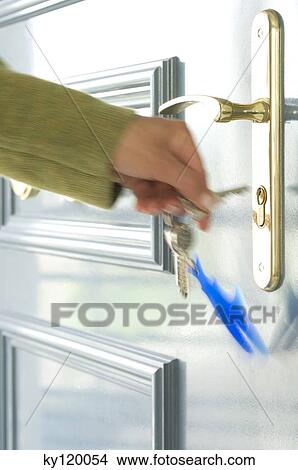 Picture - Woman locking the door, close-up. Fotosearch