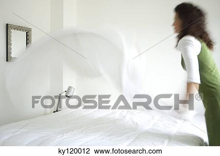 Woman making a bed View Large Photo Image Stock Image - Woman making a bed. Fotosearch