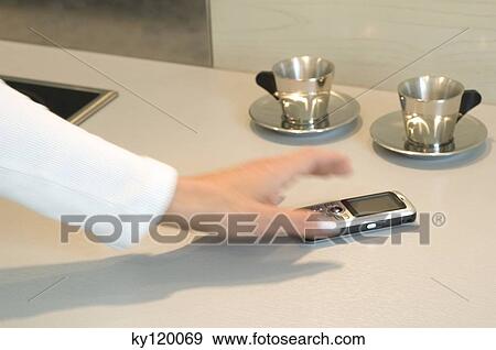 Woman picking up a mobile phone, close-up View Large Photo Image Stock Photo - Woman picking up a mobile phone, close-up. Fotosearch