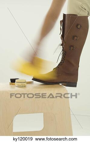 Woman polishing boots, close-up View Large Photo Image Stock Photo - Woman polishing boots, close-up. Fotosearch