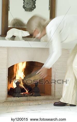 Woman putting log on hearth View Large Photo Image Stock Photography - Woman putting log on hearth. Fotosearch