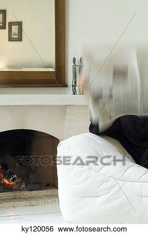 Woman reading newspaper in a living-room View Large Photo Image Stock Photograph - Woman reading newspaper in a living-room. Fotosearch