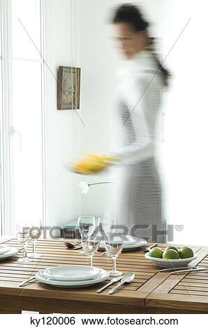 Stock Photograph - Woman setting the table. Fotosearch
