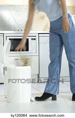 Woman throwing in the garbage View Large Photo Image Picture - Woman throwing in the garbage. Fotosearch