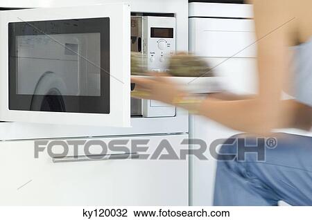Woman using a microwave, close-up View Large Photo Image Stock Image - Woman using a microwave, close-up. Fotosearch