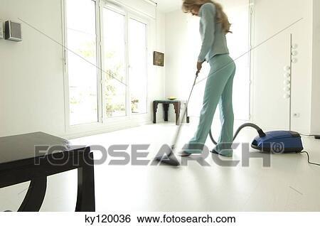 Woman vacuuming in living-room View Large Photo Image Stock Photograph - Woman vacuuming in living-room. Fotosearch