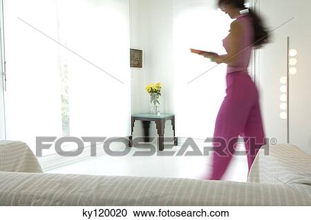 Woman walking in a living-room View Large Photo Image Stock Image - Woman walking in a living-room. Fotosearch