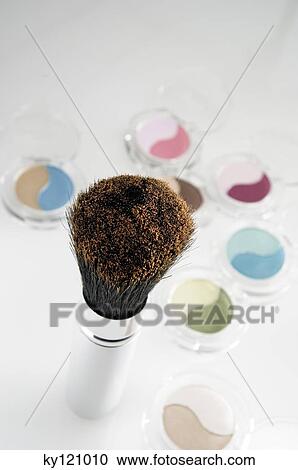 Stock Image - Eye-shadow boxes and make-up brush, close-up. Fotosearch