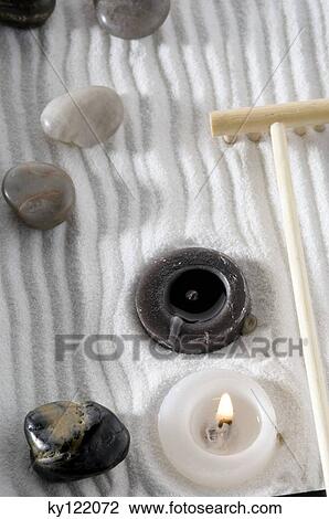 Stock Image - Candles, peebles and rake in zen garden, close-up. Fotosearch